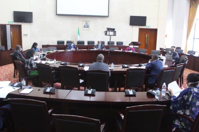Hoy jueves 22 de abril, ha tenido lugar en la Sala Plenaria del Ministerio de Hacienda, Economía y Planificación, tres reuniones organizadas por la Comisión Nacional de Coordinación de los Objetivos de Desarrollo Sostenible en Guinea Ecuatorial con los departamentos ministeriales de Industria y Energía, representada por su Ministro titular, el Departamento de Sanidad y Bienestar Social, representado por su Vice Ministro y el Departamento de Agricultura, Ganadería, Bosques y Medio Ambiente, representado por el Secretario de Estado XXX. El objeto de estas reuniones, era el de continuar con la ronda de reuniones iniciadas ayer con todos los departamentos ministeriales, en el que cada departamento, explica el Plan Sectorial que ha elaborado para luchar contra el Covid19, en el marco de la implementación del Decreto 43/2020 de fecha 31 de marzo de 2020. Al igual que ayer, las reuniones han sido presididas por el Excmo. Sr. Ministro de Hacienda, Economía y Planificación, asistido del resto de los miembros de la Comisión:el Excmo. Ministro de Justicia, Culto e Instituciones Penitenciarias, el Excmo. Ministro Delegado de Interior y Corporaciones Locales, el Excmo. Ministro de Industria y Energía, la Excma. Secretaria de Estado Encargada de Planificación y Seguimiento del Plan Nacional de Desarrollo , la Excma. Secretaria de Estado encargada de la Tesorería, el Excmo. Secretario de Estado de Presupuestos y Control Financiero, y los respectivos directores Generales, entre otros. Durante de las sesiones de la jornada de hoy se han debatido los siguientes aspectos: 1. Para el Ministerio de Sanidad y Bienestar Social. Este departamento ministerial ha presentado dos programas complementarios. Por un lado, el Plan de Reforzamiento del Sistema de Salud para la Respuesta Nacional contra el Covid19 en Guinea Ecuatorial. Se trata de un Plan en el que se desagregan las actividades de los 12 componentes de reforzamiento de un sistema Sanitario recomendadas por la Organización Mundial de la Salud. El representante de dicho departamento, ha expuesto en éste punto, el detalle de las actividades que van desde la prevención, la mitigación, la adquisición de equipamiento y la comunicación contra el Covid19. Para este plan específicamente, si bien el sector fue felicitado por su excelente trabajo, la Comisión Nacional de Coordinación le sugirió revisar el presupuesto de las actividades, así como incluir mayor detalle sobre sobre resultados esperados, mecanismos de seguimiento y evaluación del plan, para que su impacto pueda ser medible. El segundo programa presentado por dicho departamento, fue el Proyecto de Refuerzo de la Prestación de Servicios de la Salud en Guinea Ecuatorial. Este Proyecto ha sido concebido específicamente para acceder a los 15.000.000.000 quince mil millones de francos que el Banco de Desarrollo de los Estados de África Central (BDEAC), pone a disposición de cada país miembro de la subregión, para hacer frente a los efectos del Covid19. Si bien dicho proyecto constaba de todos los detalles explicativos, se le ha recomendado al departamento incluir adjuntar en anexo, una mayor desagregación de las actividades y el presupuesto. 2. Para el Ministerio de Industria y Energía. Se han presentado un paquete de propuestas relativas a eximir a los usuarios (físicas y jurídicas) del pago del fluido eléctrico durante el tiempo que dure el Covid19. Dichas personas físicas y jurídicas, engloban hoteles, restaurantes, consumidores individuales (pequeños y medianos con determinado volumen de consumo mensual), discotecas, bares, casinos y aquellos establecimientos públicos cuya actividad ha sido completamente cerrada por el Estado de Emergencia Sanitaria. Sin embargo, dada la dificultad de identificación clara de dichos grupos, y la necesidad de un mayor análisis sobre el impacto que supone dicha medida para el Gobierno, así como del cuidado de la estabilidad financiera de la propia empresa Segesa, se ha recomendado a dicho departamento, hacer unos análisis más profundos y con información precisa sobre el impacto y los mecanismos de compensación que utilizará el Gobierno con dichos grupos. 3. Para el Ministerio de Agricultura, Ganadería y Bosques y Medio Ambiente. El departamento presentó el Plan Nacional de Evacuación de los productos Agrícolas de la periferia a los mercados de las principales ciudades del país. El plan constará de dos fases. Un primer periodo de ejecución estimado de Abril a Junio de 2020, y un segundo periodo que va de Julio a Septiembre de 2020. En cada una de las fases, el departamento tiene por objetivo proveer a los mercados nacionales de los productos agropecuarios de primera necesidad, evitando al máximo las roturas de stock, las subidas de precios y la movilidad de los consumidores. El departamento también fue felicitado y se le requirió el establecimiento de un mecanismo anti riesgo de rotura futura de la cadena de suministro analizando cada uno de los posibles riesgos y proveyendo las correspondientes estrategias de solución. A modo de conclusión, los planes sectores de lucha contra los efectos del Covid19, están ya en la fase de conclusión. A medida que avancen las reuniones y se vayan definiendo las versiones finales de dichos planes, el Ministerio de Hacienda, Economía y Planificación como ministerio tutor, copresidente de la Comisión Nacional de Coordinación de los ODS en Guinea Ecuatorial, presentará en la mayor brevedad posible, todos los planes de acción. Dicho departamento, está trabajando simultáneamente en el análisis y la identificación de todas las posibilidades fuentes de financiación nacional y extranjera (de los Organismos Económicos y Financieros Internacionales), para que dichos planes sean puestos en marcha, con efectos inmediatos, una vez sean aprobados por el Gobierno. Mañana, 24/04/2020, les toca el turno a los departamentos de Seguridad Nacional, Pesca y Recursos Hídricos y de nuevo, al Ministerio de Educación, Enseñanza Universitaria y Deportes, para recibir la versión definitiva del Plan elaborado por dicho sector, tras las correcciones recomendadas en la reunión del pasado 22/04/2020.
